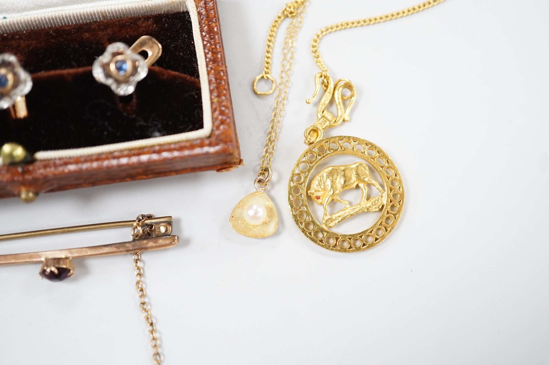 A small collection of jewellery to include a yellow metal Taurus medallion, a small yellow metal and gem set bar brooch, a 9ct gold and cultured pearl pendant and an Austro Hungarian yellow metal, paste and cabochon set